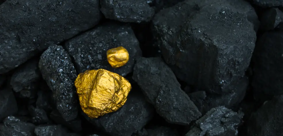 a gold stone on black stones